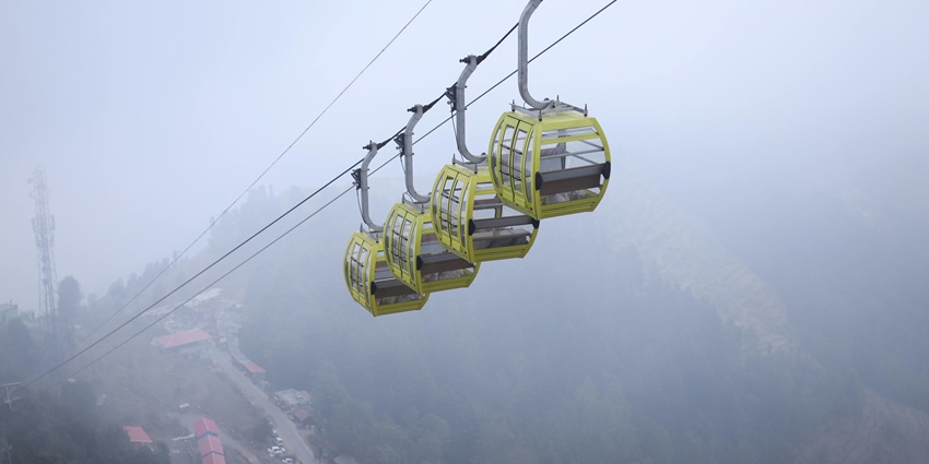 A mesmerising view of Kanatal featuring snow-capped mountains and cable cars.