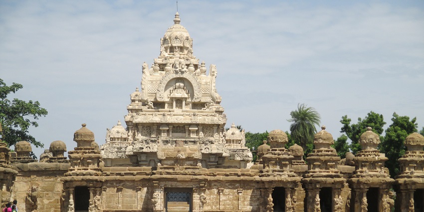Outside of Kailasanathar temple, two women walking in front of the grand structure