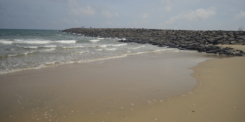Image of Karaikal Beach shoreline near the stones where people stroll around