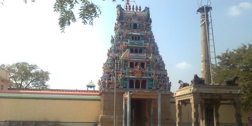 Colourful, intricately decorated gopuram of Kariyakali Amman Temple in an open courtyard