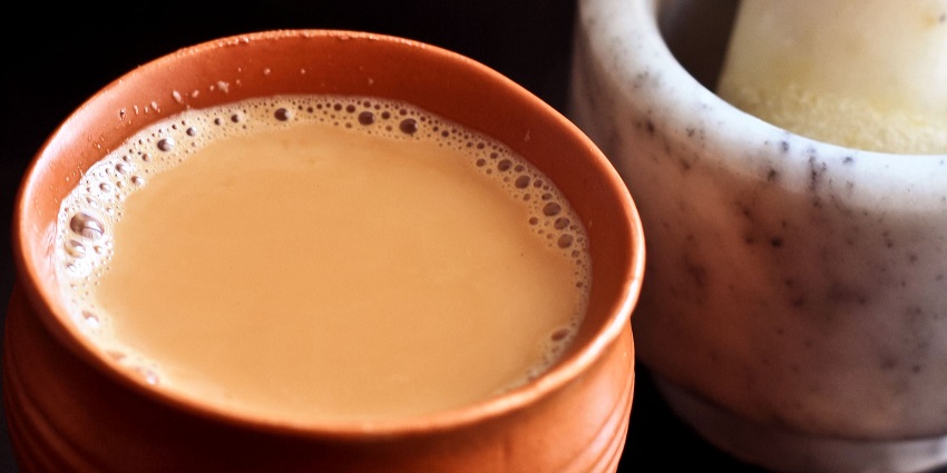 A vendor pouring hot tea from the kettle on a street in Varanasi