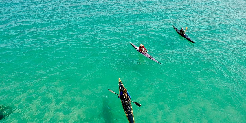 An image of a person kayaking peacefully along the shoreline at Juhu Beach.
