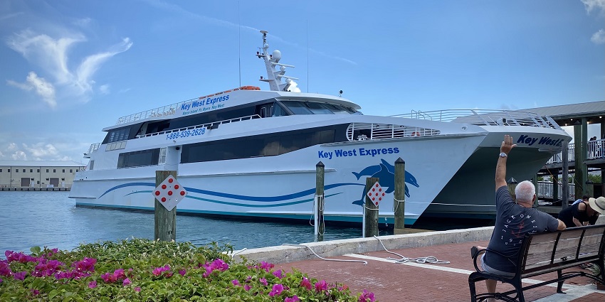 Key West Bight ferry terminal with a yacht and a couple of people sitting on a bench