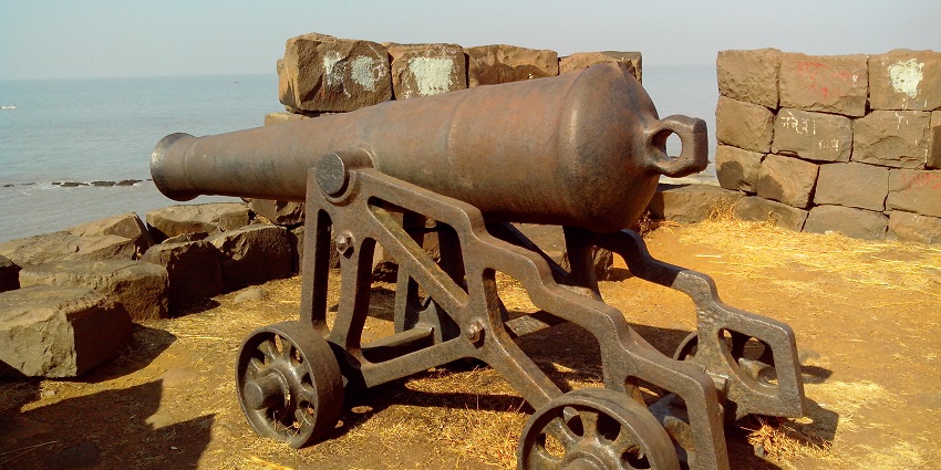 A rusty cannon mounted on a stone platform at Khanderi fort in Maharashtra.