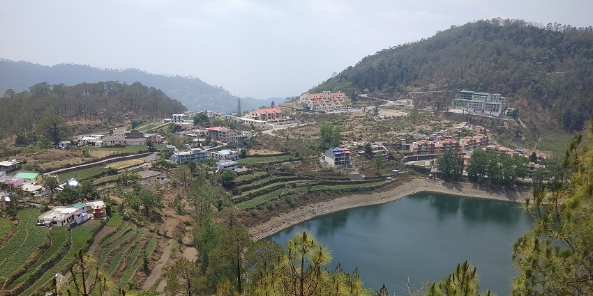 Green waters of a tranquil lake in Khurpatal in the hills of Rishikesh
