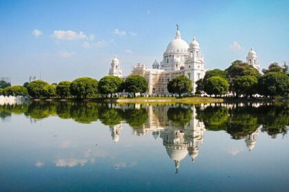 An image of Victoria Memorial Hall, Kolkata, a large white building sitting on top of a lake.