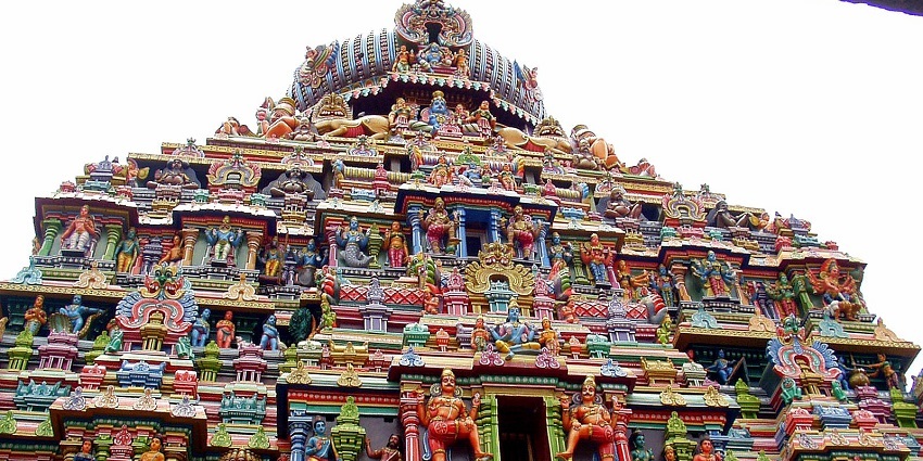 Intricate carvings and sculptures adorn the towering gopuram of a South Indian temple.
