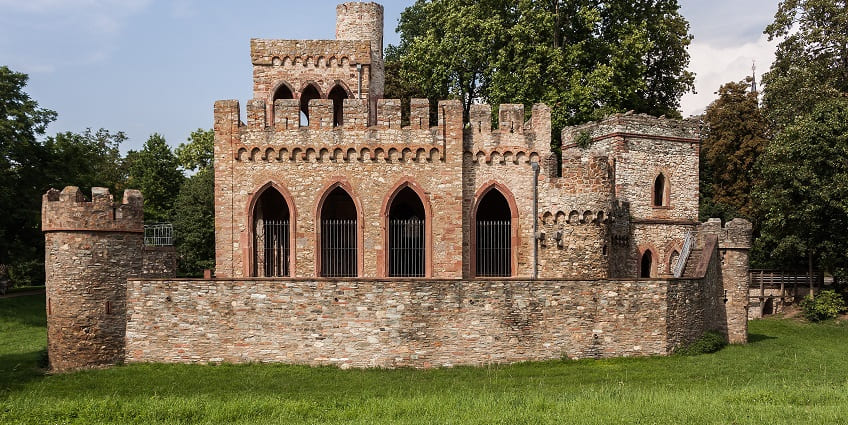 A frontal view of a historical palace located in Naimisharanya, surrounded by lush greenery