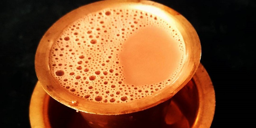 A cup of Kumbakonam Degree Coffee, showcasing the rich brown beverage with a layer of froth on top.