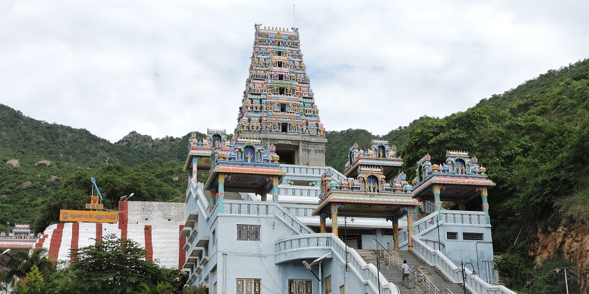 A view of a traditional temple with stairs leading to the main complex and a tall Gopurama