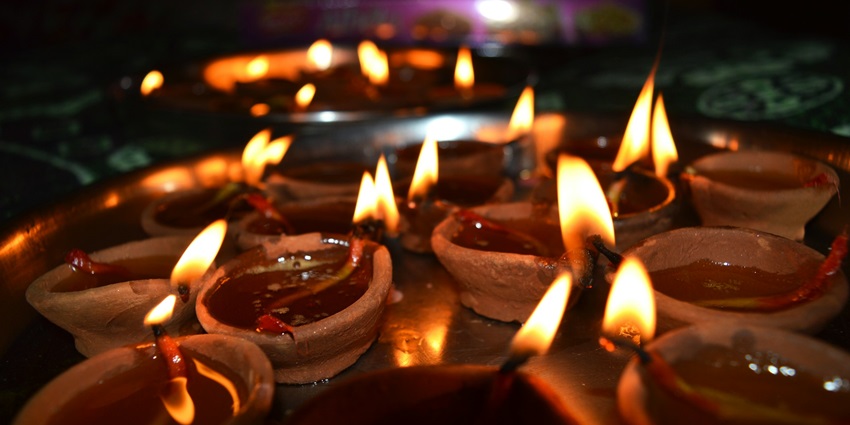 A group of lit candles in a dark setting, creating a warm and serene ambiance
