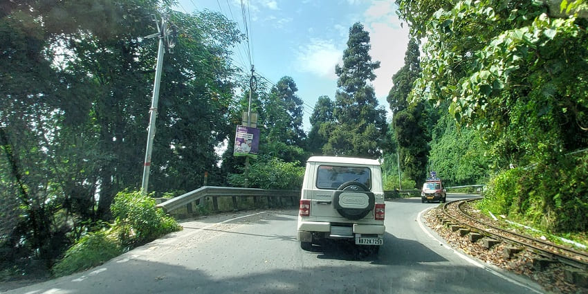 A peaceful road in Kurseong, with lush greenery on both sides