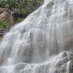 A scenic view of Kutladampatti Waterfalls surrounded by greenery in Vadipatti, Tamil Nadu.