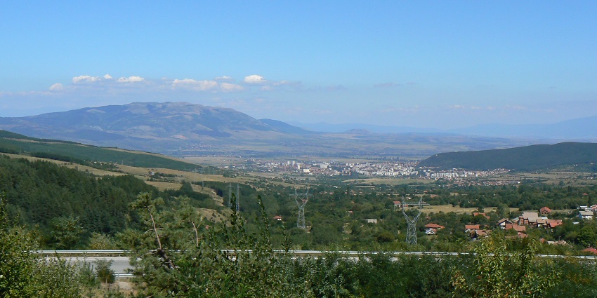 Kyustendil town with towns in the distance, electricity towers and Konyavska mountain.