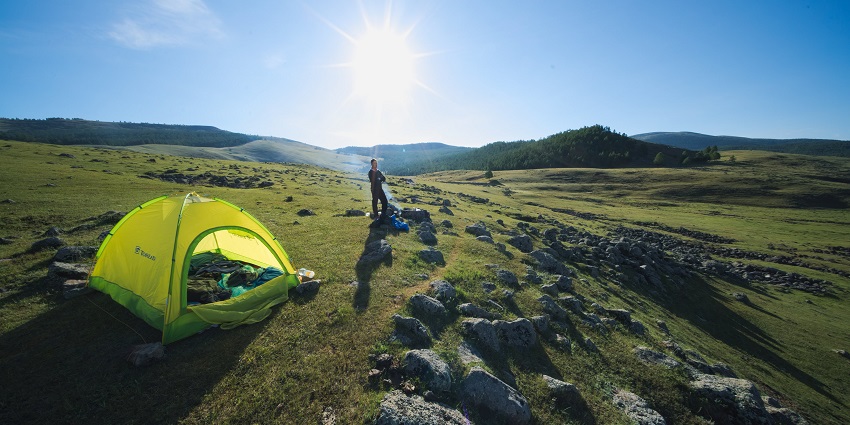 A lush expanse near the Tehri lake with camping tents placed over it