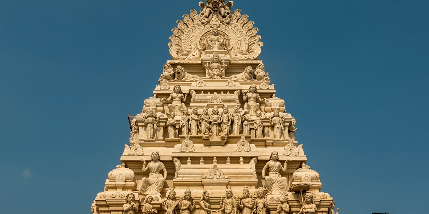 An outside view of a temple showcasing intricately carved sculptures on the outer surface