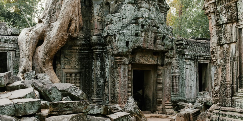 A picture of the entrance of a historical temple in Wagholi, surrounded by forest area and rock structures