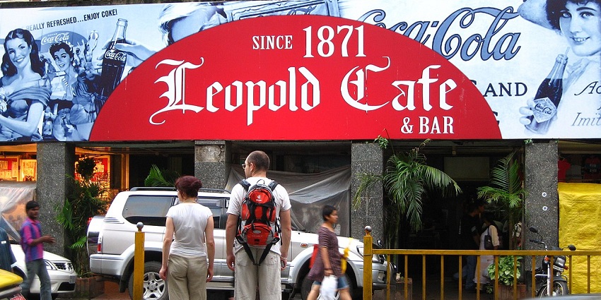 A busy day in Leopold Cafe in Mumbai with people ordering food and enjoying their meal