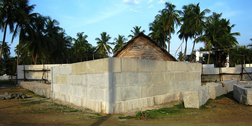 Outside of Sri Linga Bhairavi Temple, surrounded by green palm trees, on the landscape.