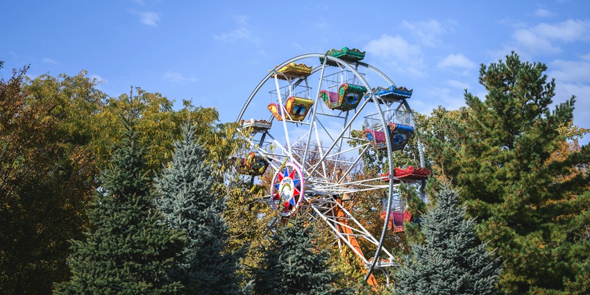 Image of an adventure rides for children - surrounded by lush greenery trees and hills during day time view