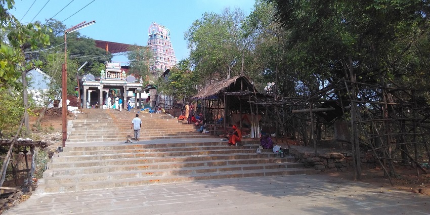 Stairway leading to Mailam Temple with people walking and resting along the steps