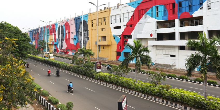 Wallajah Road of Chennai with two lanes filled with vehicles and separated by a divider.
