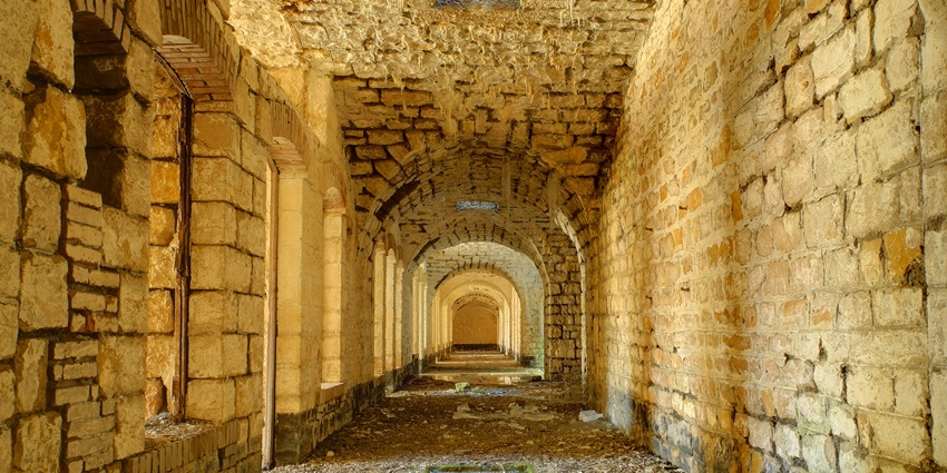 Historic stone fort with tall walls and turrets, set against a spectacular backdrop.