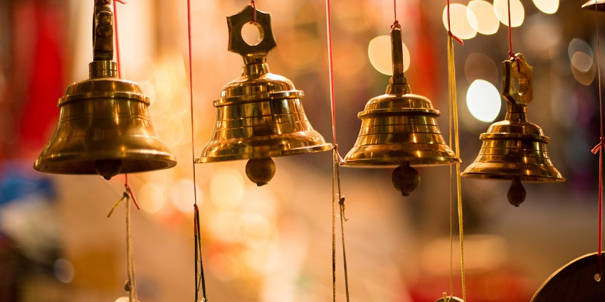 Image of temple bells - temple with intricate architecture featuring a tall spire surrounded by greenery
