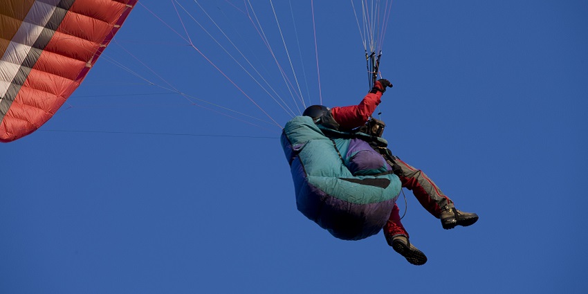 Paragliding in Dehradun with mountains and breathtaking valleys in the background.