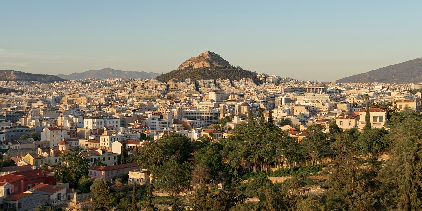Athens city from the top of the Areopagus with colourful buildings and distant mountains.