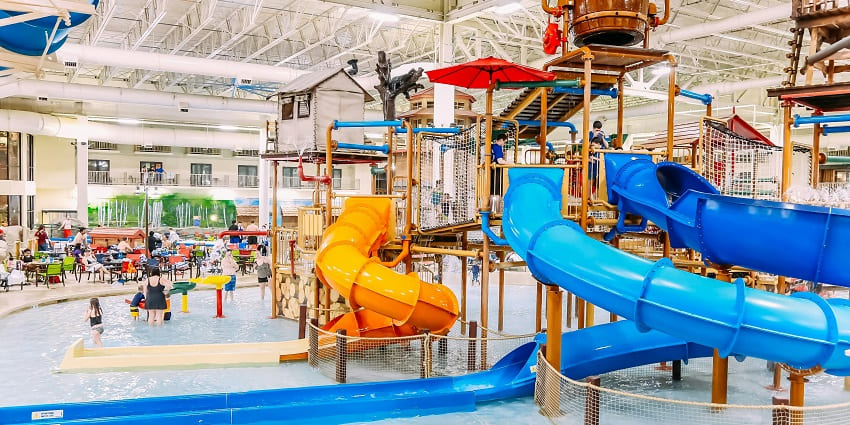 water slides at Fantasy World Water Park, curving into a pool with green trees behind