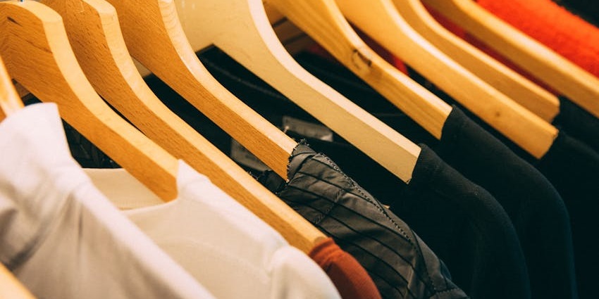 Assorted clothes hanging on a black steel rack in a boutique setting–street shopping in coimbatore