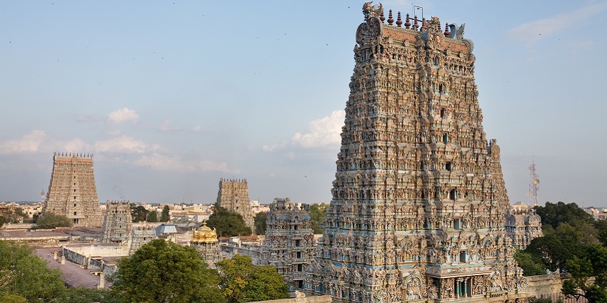 The vibrant gopuram tower of Meenakshi Temple in Madurai, covered in intricate sculptures.