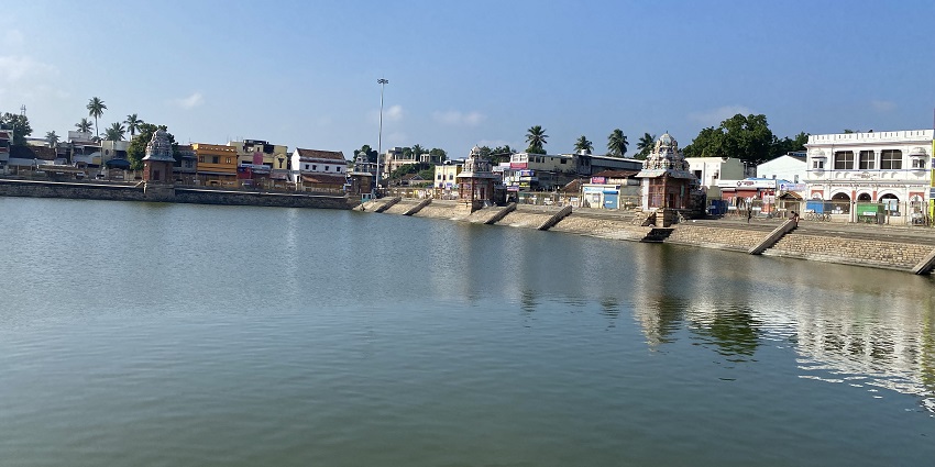 Serene water of Mahamaham Tank surrounded by stairs leading to the ancient temples