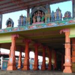 Mailam temple entrance with colourful statues and orange pillars under a metal roof