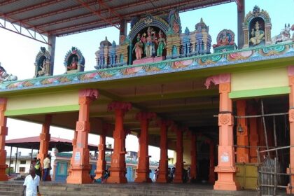 Mailam temple entrance with colourful statues and orange pillars under a metal roof