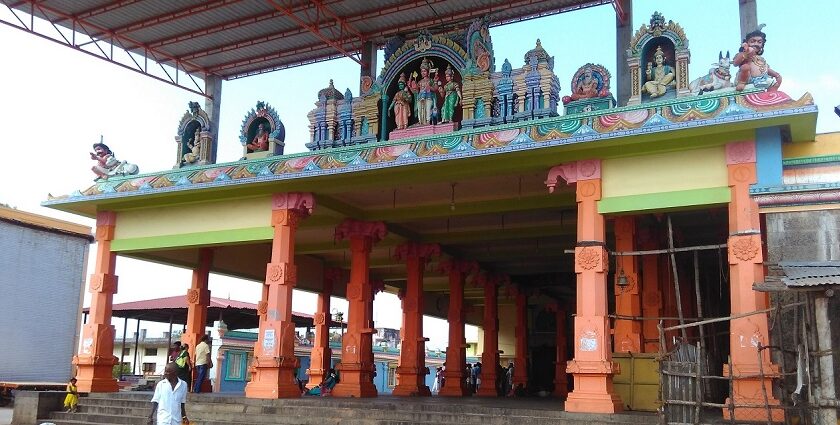 Mailam temple entrance with colourful statues and orange pillars under a metal roof