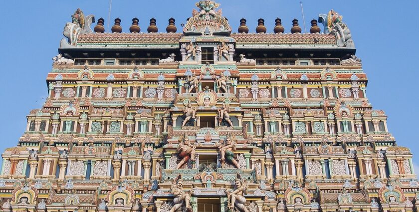 The outer view of a temple featuring Gopuram artwork consisting of various deities.