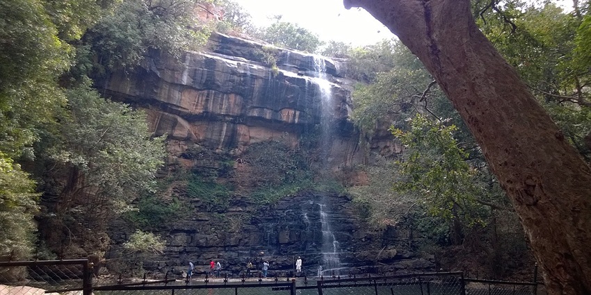 Mallela Theertham Waterfall in dense forest flowing from heights surrounded by natural boulders