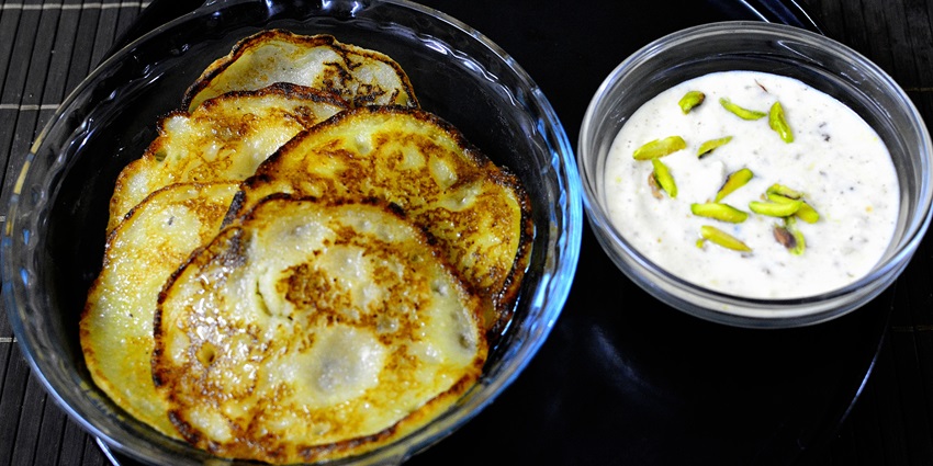 A delicious plate of Malpua with condensed milk, dry fruits and a dash of cottage cheese