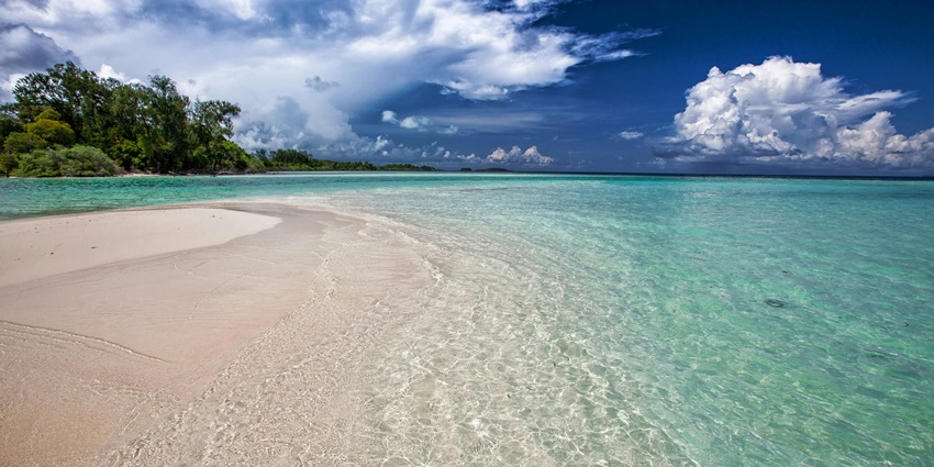 The peaceful Mamba Beach near calm waters, showcasing soft sands and gentle waves.