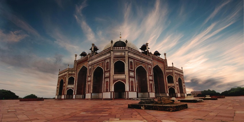 A majestic brown and black mosque featuring the tomb of famous India Mughal king.