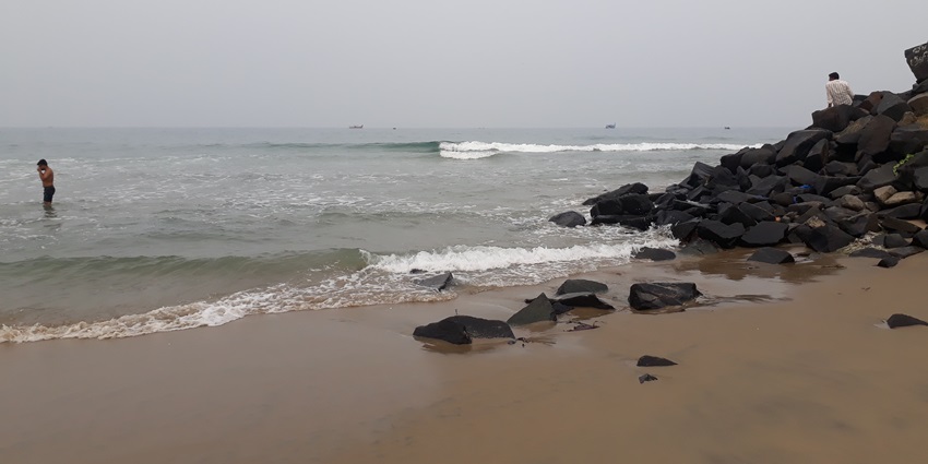 A picture of a tide approaching the serene golden sand of a beach near Malaiyanur Temple