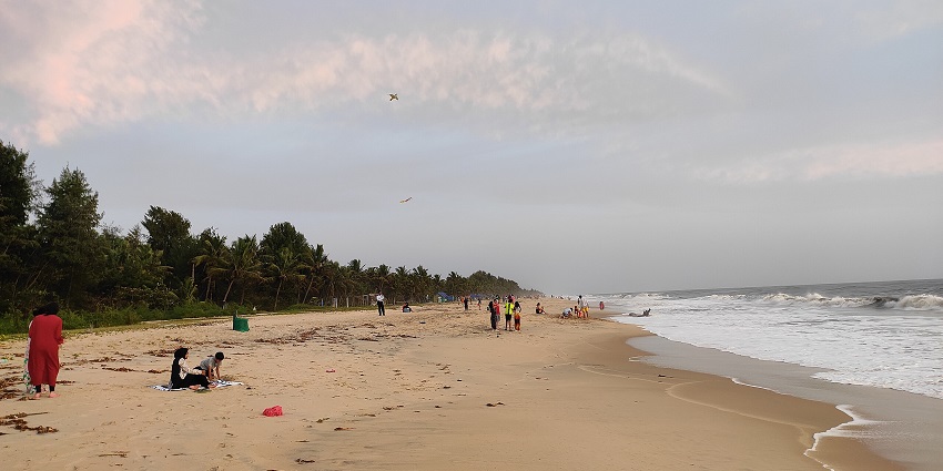 A breathtaking view of a beach with azure waters and a sandy shoreline with many tourists.