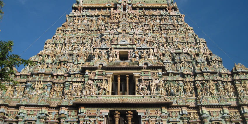A frontal view of the majestic and colourful gopuram of a historical Hindu temple