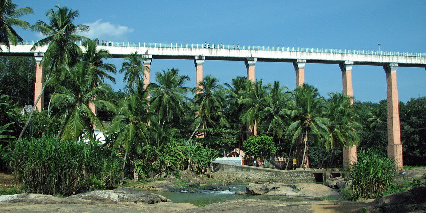 The Mathur Hanging Bridge is a long suspension bridge surrounded by lush greenery.