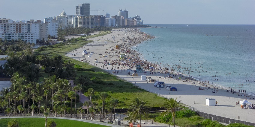 Miami beach from the top with lots of people visiting the beach and tall skyscrapers