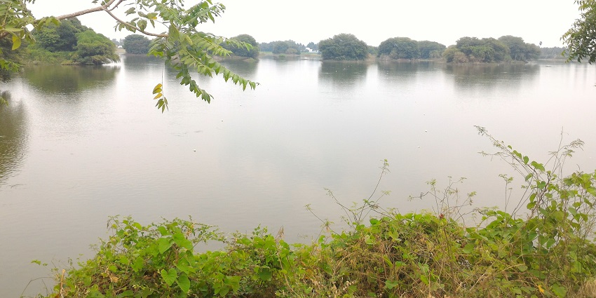 A stunning view of Mookeneri Lake with calm waters surrounded by distant hills.
