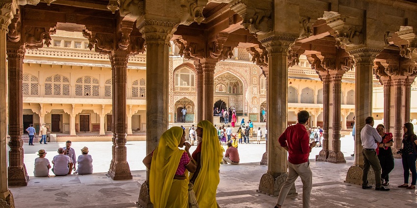 Temple arcade with tall pillars and intricate carvings, creating a majestic walkway.