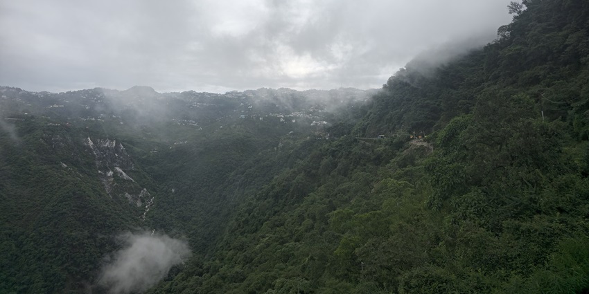 Panoramic view of Mussoorie town nestled in green hills with distant mountain backdrop—hill stations near lucknow